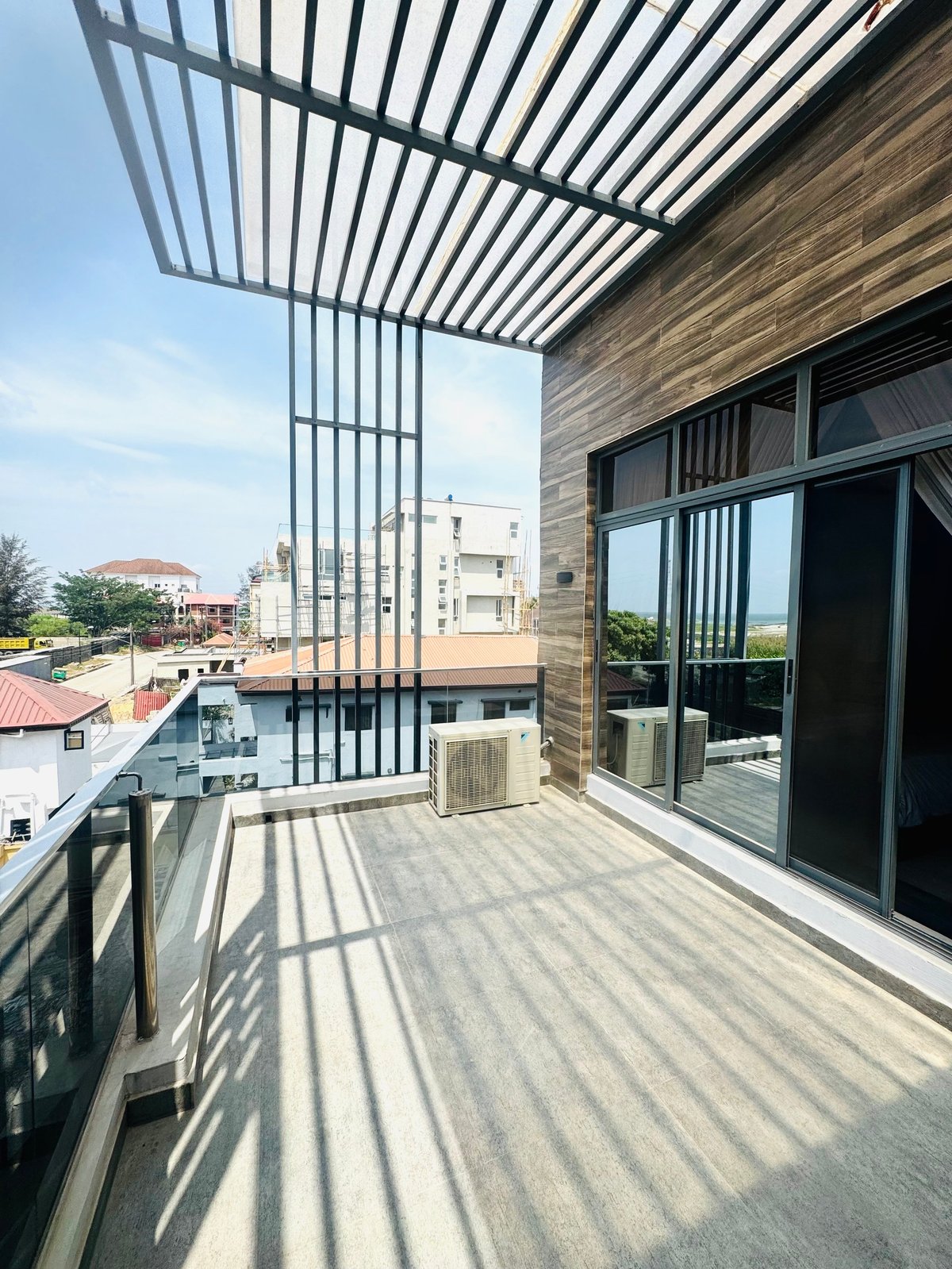 Rooftop terrace with slatted pergola, wooden wall and city views