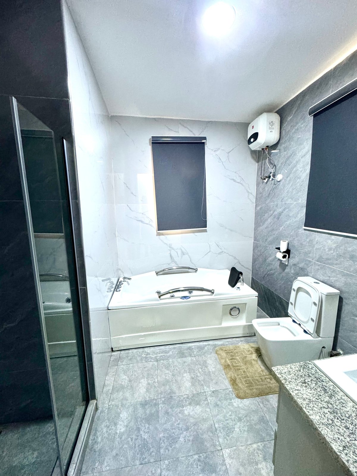 Bathroom with white marble walls, soaking tub, walk-in shower and sink